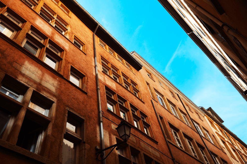 Looking up at an ochre building with a wrought-iron lantern
