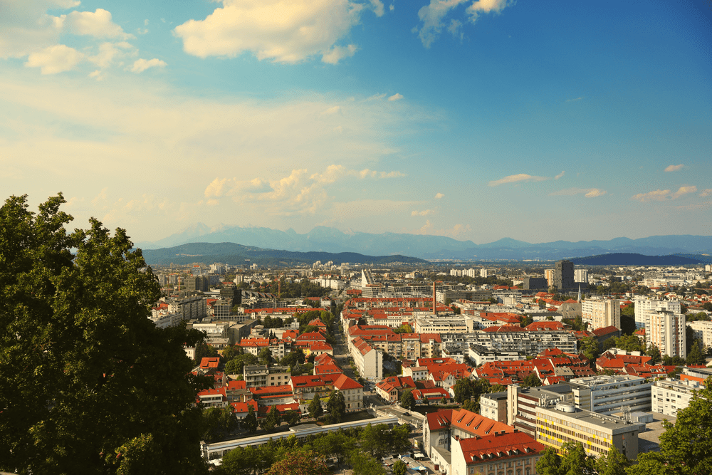 Aerial view of Ljubljana's red rooftops with the Alps on the horizon