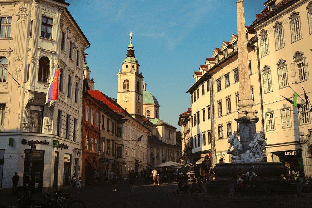 Ljubljana's old town square with a baroque fountain and cathedral tower at golden hour