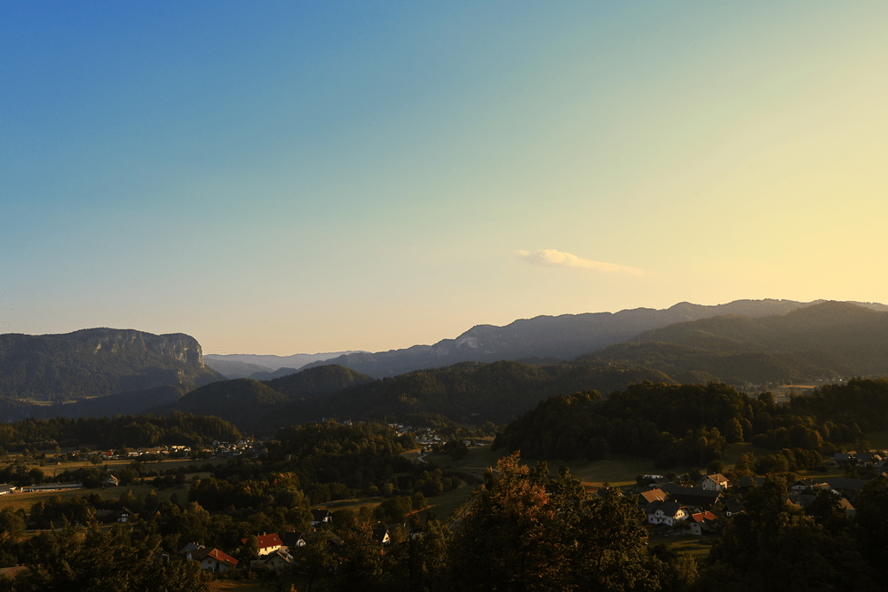 Bled Castle on its cliff catching the last light above the village at dusk